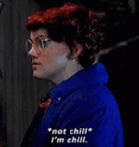 a woman with red hair and glasses is wearing a blue jacket and tie and says not chill i 'm chill .