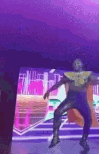 a man is dancing in front of a screen with a purple background