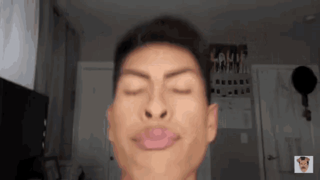 a young man is making a funny face with his eyes closed and his mouth open .