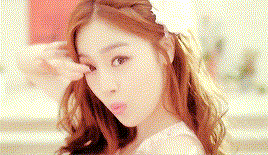 a close up of a woman 's face wearing a white dress and a flower in her hair .