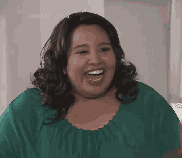 a woman in a green shirt is smiling with the words clouds plus written on the bottom