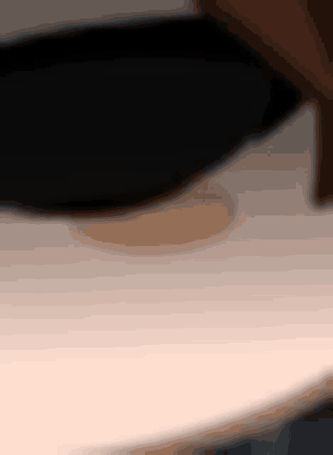 a close up of a person 's face with a black hat on a table .