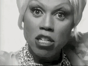a black and white photo of a woman wearing a necklace and earrings .