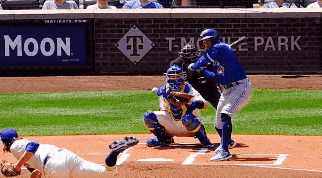 a baseball player swings at a pitch in front of a t mobile park sign