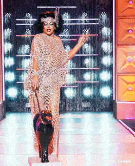 a drag queen is walking down the runway with a black cat