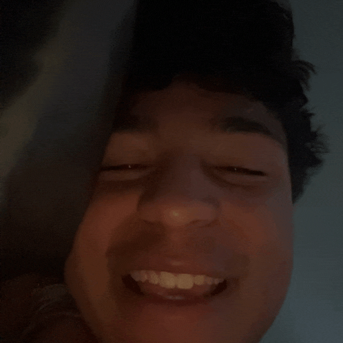 a close up of a person 's face with their eyes closed and a smile on their face