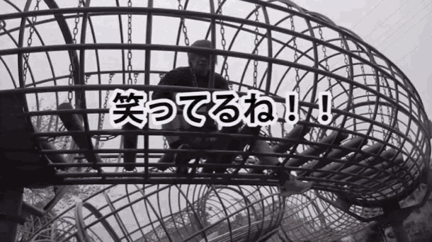 a man is sitting in a cage with chinese writing on the bottom
