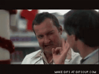 a man in a white coat is talking to another man in a store