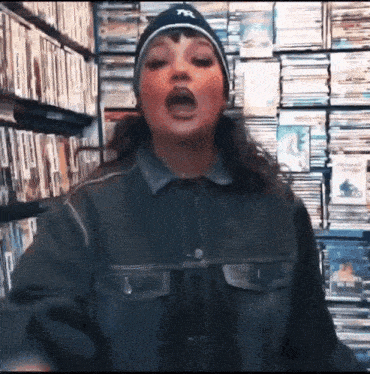 a woman wearing a ny hat and jacket is singing