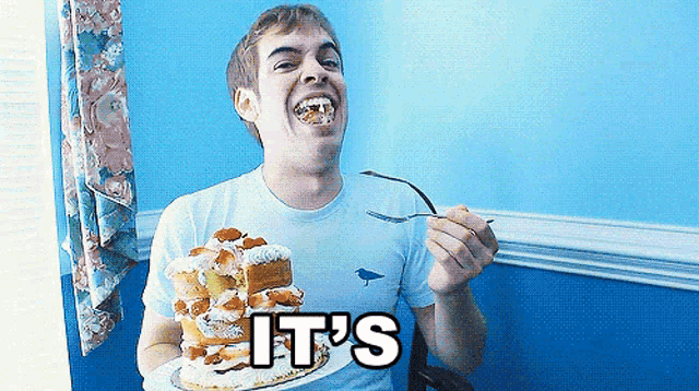 a man in a blue shirt is eating a cake with the words it 's below him