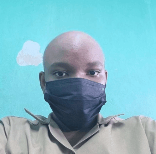 a bald man wearing a black mask looks at the camera