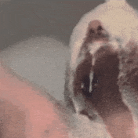 a close up of a person 's face with a blurred background and a reflection of a person in a mirror .