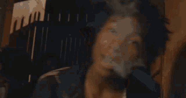 a man with dreadlocks is holding a gun in a dark room .