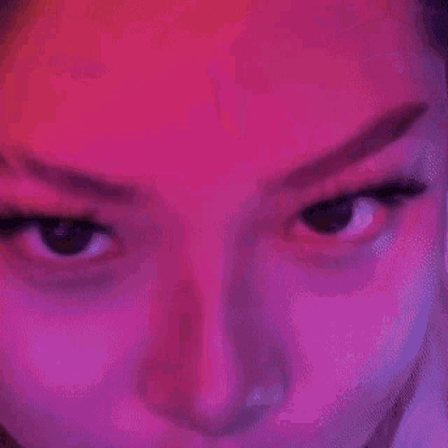 a close up of a woman 's face with a pink background .
