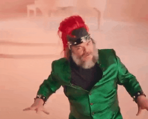 a blurry picture of a person in a green suit holding a red balloon