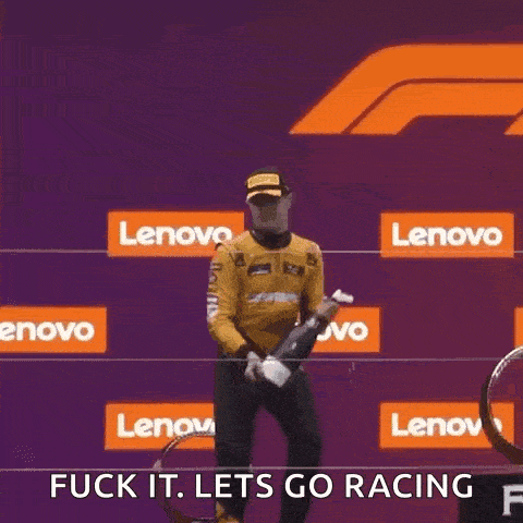 a man is holding a trophy and a bottle of champagne in front of a lenovo sign .