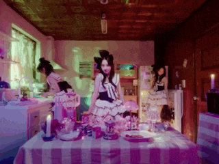 a woman in a dress is standing in a kitchen