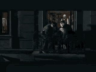 a man is hanging upside down from a ceiling in a dark room