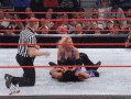 two women are wrestling in a ring with a referee in the background
