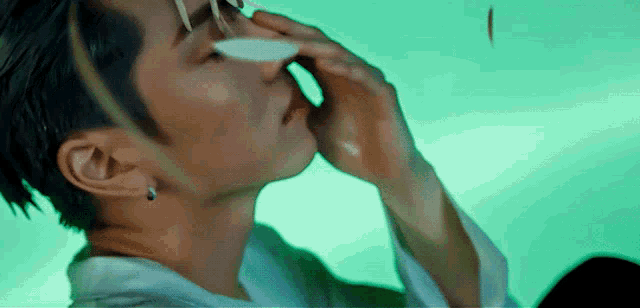 a close up of a man covering his face with his hand