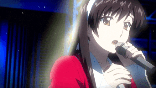 a girl in a red jacket is singing into a microphone in a dark room