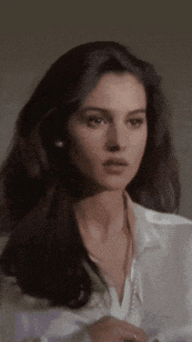a woman with long dark hair is wearing a white shirt