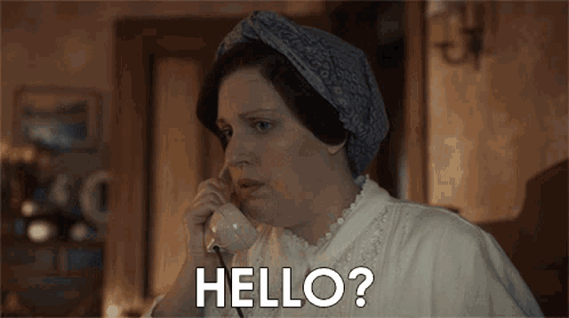 a woman talking on a telephone with the words hello written on the bottom