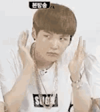 a young man is making a funny face with his hands in front of his face in chinese .