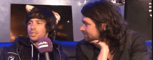 two men are talking to each other and one has a purple microphone with the word solution on it