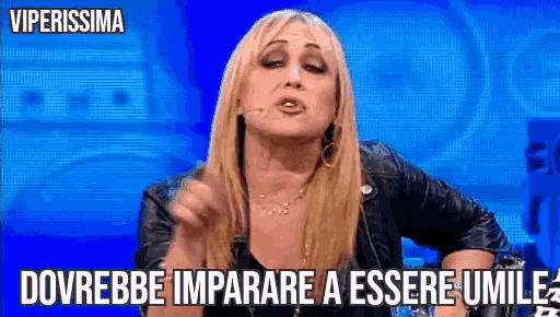 a woman in a leather jacket is making a funny face with the words dovrebbe imparare a essere umile above her .