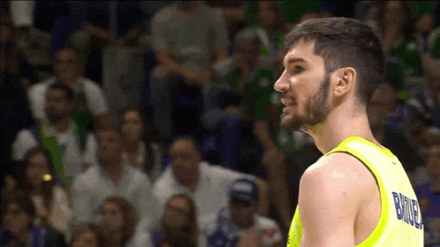 a basketball player wearing a yellow jersey with the name birla on it