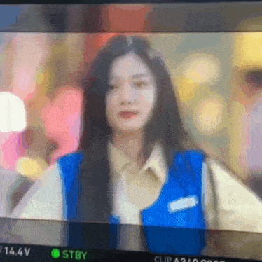 a blurry picture of a woman in a blue vest with the letters stby on the bottom