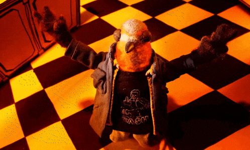 a stuffed animal wearing a shirt that says ' mr. rash ' on it is standing on a checkered floor