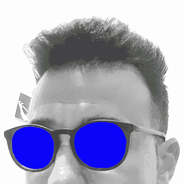 a man wearing sunglasses with blue lenses looks at the camera in a black and white photo