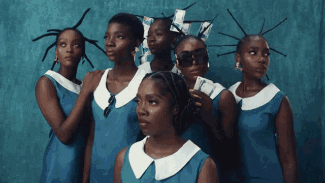 a group of young women wearing blue dresses and white collars