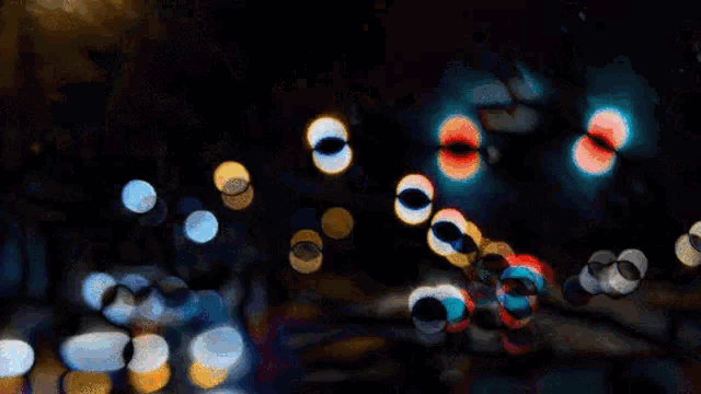 a blurry picture of a street at night with traffic lights