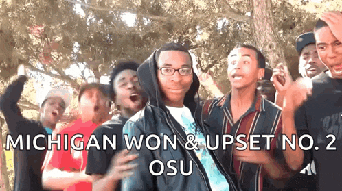 a group of young men are celebrating a win for michigan