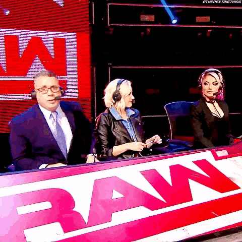 a man and two women are sitting in front of a sign that says raw on it