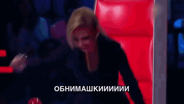 a woman is sitting in front of a red chair with russian writing on the bottom
