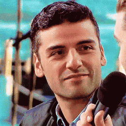 a man is holding a microphone in his right hand and smiling
