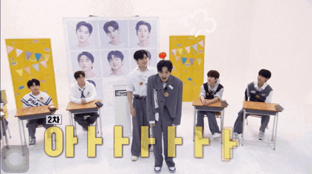 a group of young men are standing in front of a sign that says ' 2 차 '