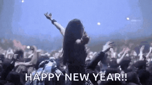 a woman is dancing in front of a crowd of people at a concert and says `` happy new year '' .