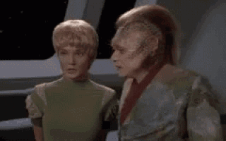 a man and a woman standing next to each other on a space ship .