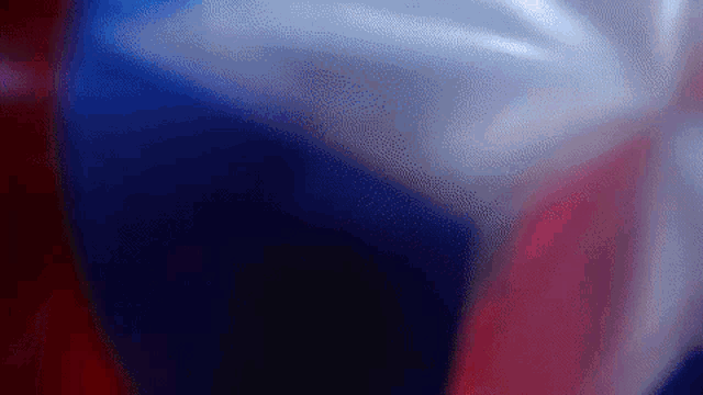 a red , white and blue background with a blurred texture