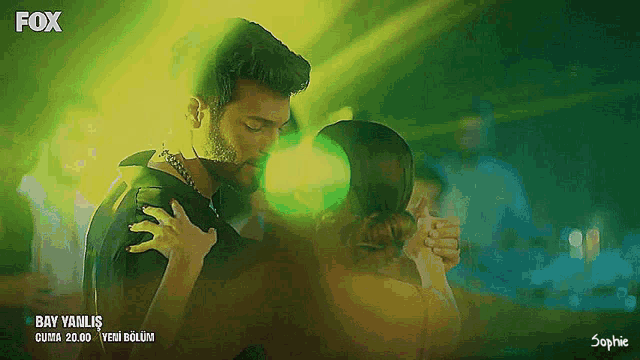 a man and a woman are dancing in front of a green background that says fox