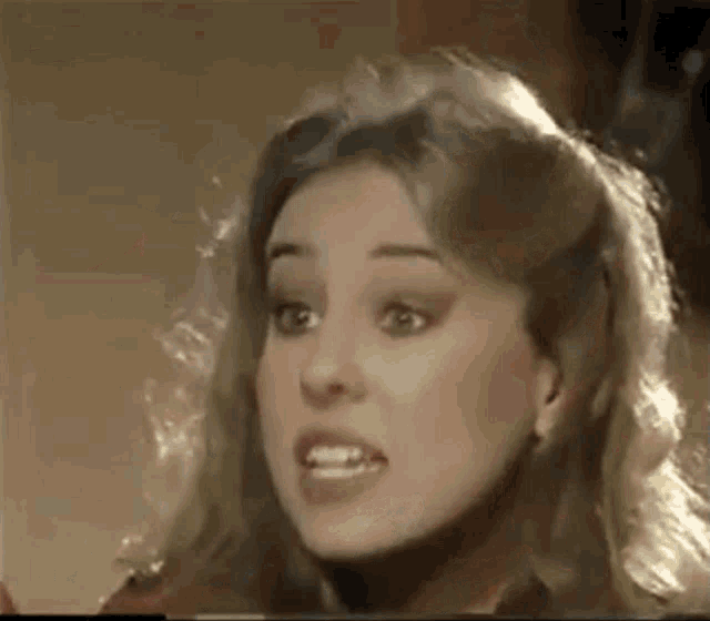 a woman with blonde hair is making a funny face in a video .