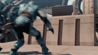 a man in a blue armor is standing in front of a building in a video game .