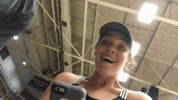 a woman is holding a cell phone in her hand and smiling .