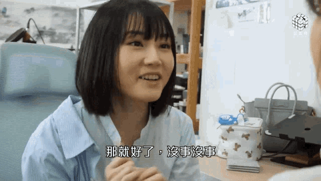 a woman in a blue shirt is talking to another woman in a foreign language