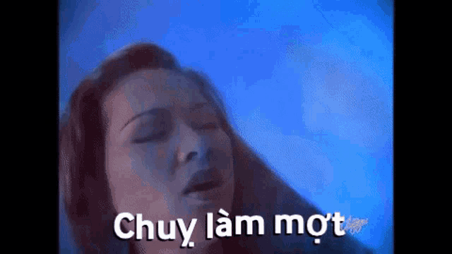 a woman with her eyes closed and the words chuy lam mot written in white